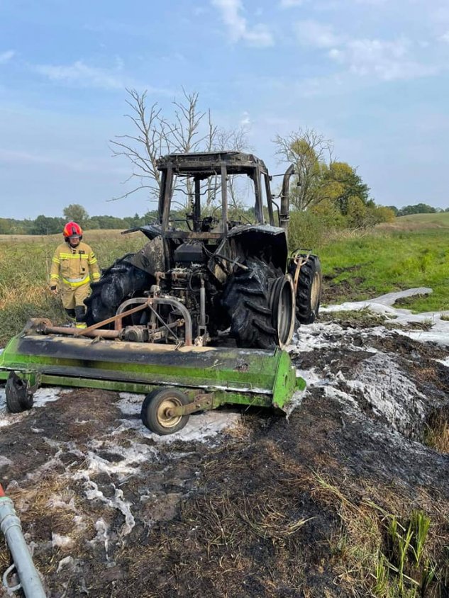 Strażacy ratowali płonący na polu ciągnik