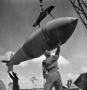 Wikipedia. Royal Air Force Bomber Command, 1942-1945. A 12,000-lb MC deep-penetration bomb (Bomber Command executive codeword 'Tallboy') is hoisted from the bomb dump to its carrier at Woodhall Spa, Lincolnshire, to be loaded into an Avro Lancaster of No. 617 Squadron RAF for a raid on the V-weapon site at Wizernes, France. 617 Squadron were unable to bomb the target on this occasion because of low cloud cover, but were to succeed two days later.